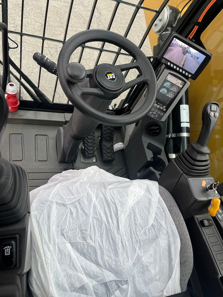 Inside Cab view of steering wheel and control panels of a Caterpillar MH 3022 Material Handler