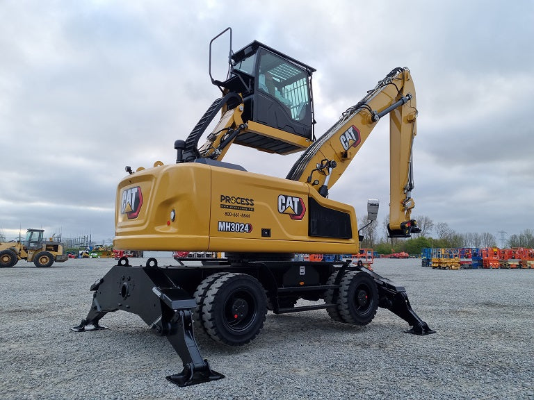 Caterpillar MH 3024 Material Handler with outriggers, solid rubber tires, a bucket linkage stick and hydraulic elevating cab