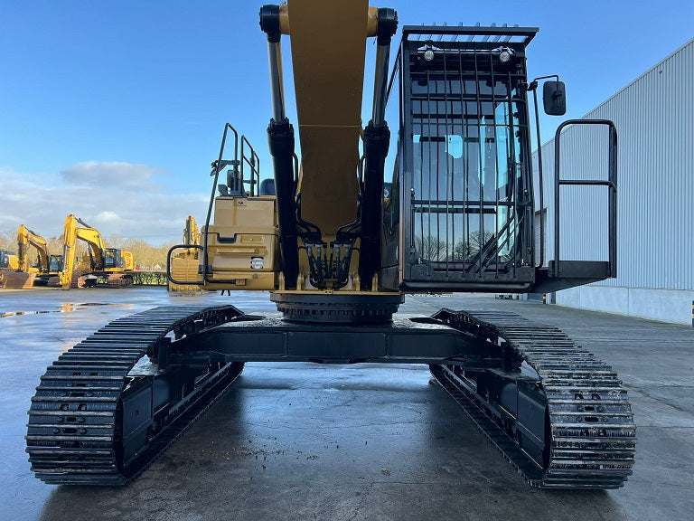 Front view of a Caterpillar MH 336F Material Handler on tracks with a front cab guard