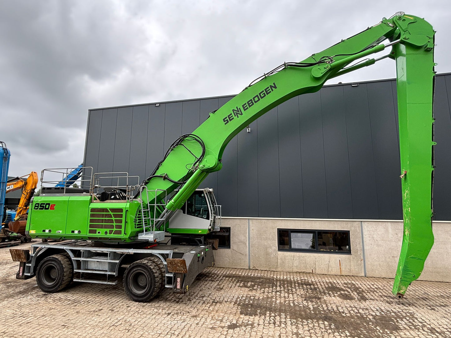 Green Sennebogen material handler with 65 foot of reach