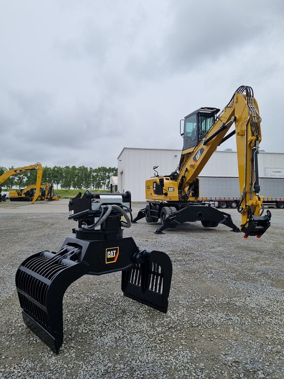 Caterpillar G315G 2-Tine trash grapple with a caterpillar material handler with bucket linkage in the background 