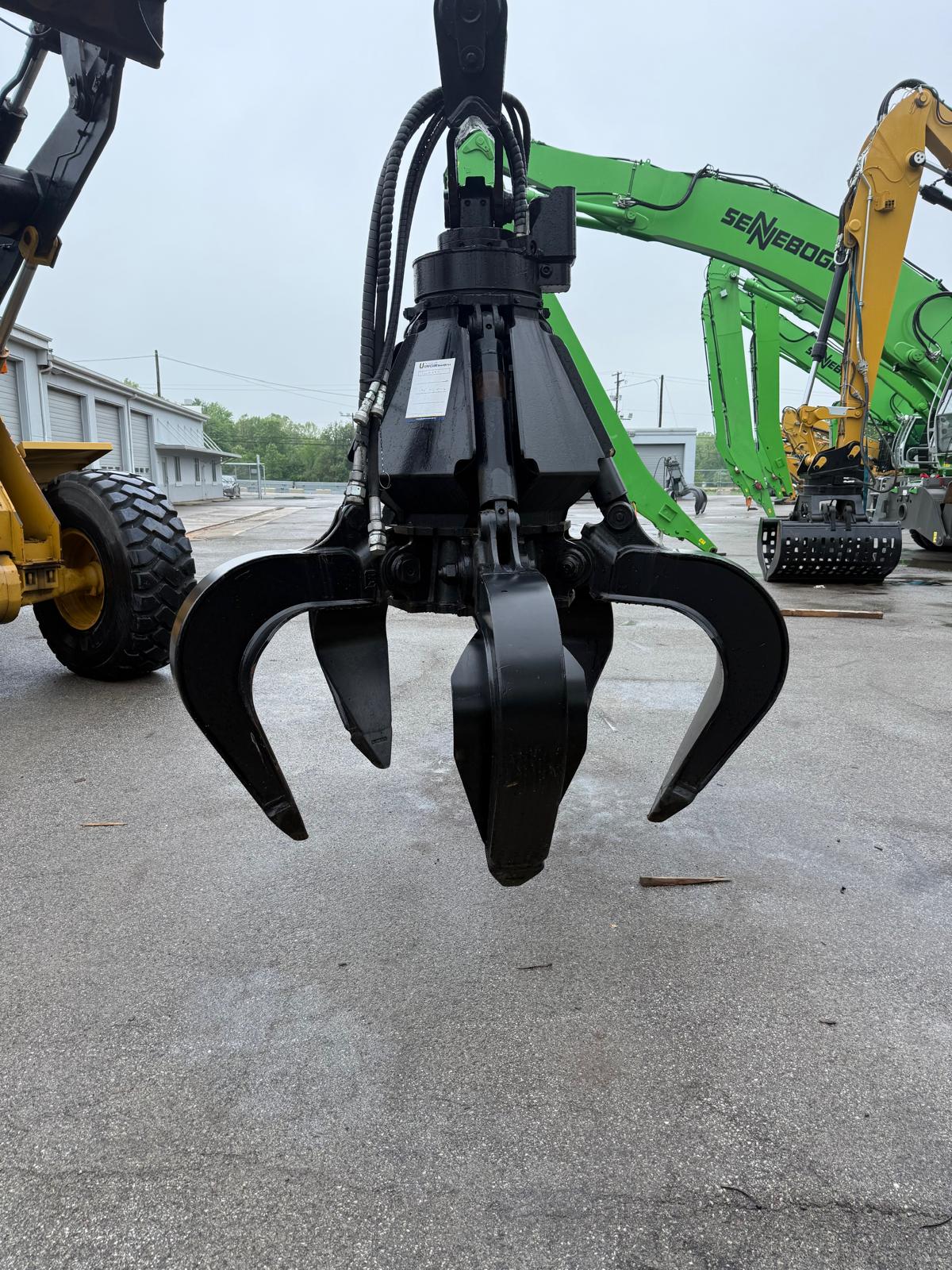 Close-up of a grapple attachment on a machine with a blurred background
